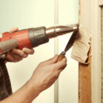 a person using a drill to remove a piece of wood