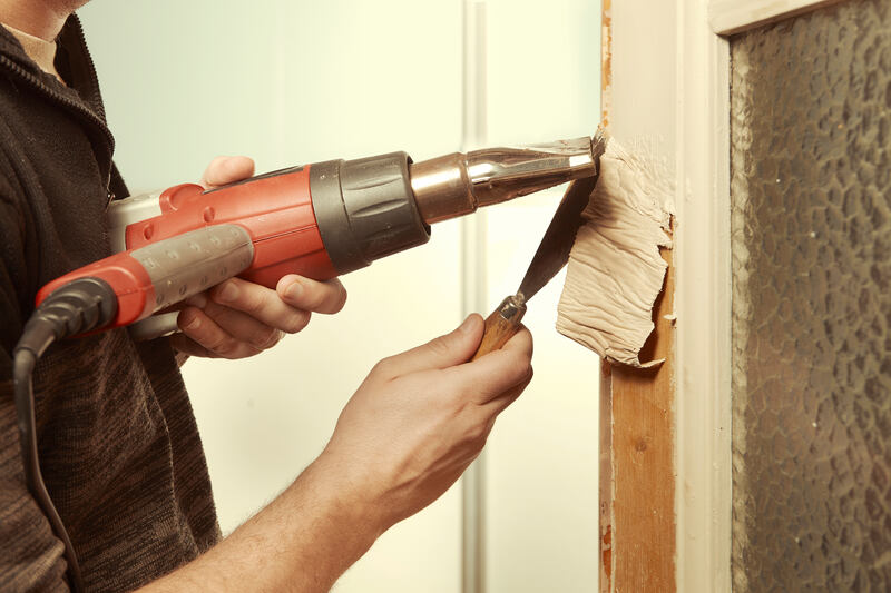 a person using a drill to remove a piece of wood